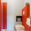Il pratico bagno con pareti color rosse - Duomo Luxury Suite