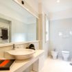 Bagno con lavabo ovale, ampio specchio e piano in legno - Cascade