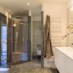 Ampio box doccia rivestito in marmo scuro - Villa Benedetta