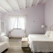 Camera da letto matrimoniale bianca con poltrona - Villa Helios